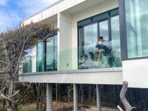 Glass railing customer enjoying breakfast on their deck overlooking the beach