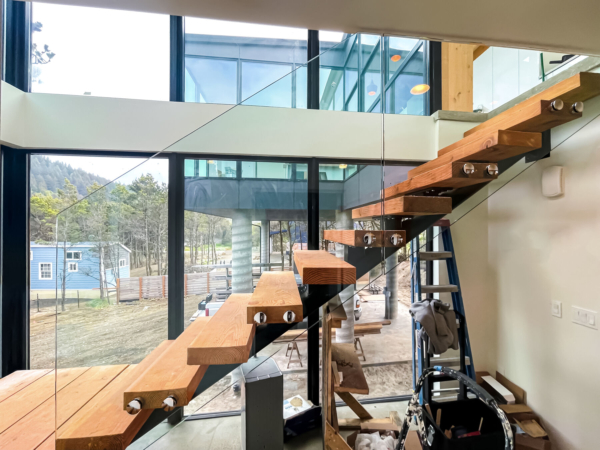 Standoff adapter frameless glass railing on stairs in Oregon coast home