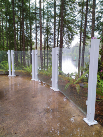 Double-post glass railing follows the bend of this curved lakeside patio