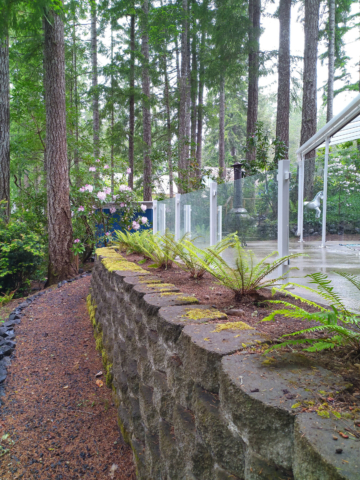 White glass railing around this forested patio