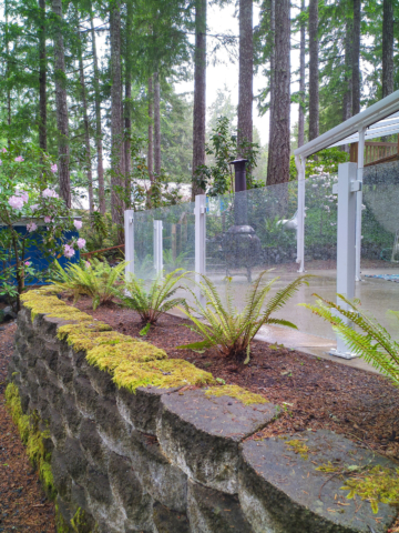 Pacific northwest forest property with a frameless glass railing