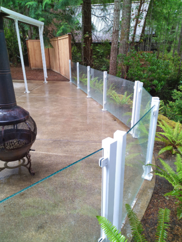 White glass railing lines this raised patio in Grapeview, WA