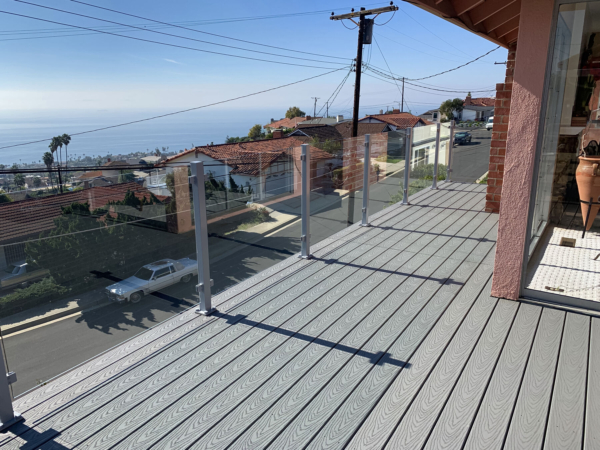 Frameless glass railing subtly accents this stucco home along the Californian coast