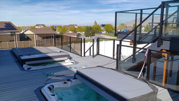 Tinted glass panels are used in the glass railing around the pool and hot tub area for a subtle layer of privacy without sacrificing the view.