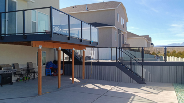 Long shot of all the decks lined with glass railing in this Tooele, UT backyard.